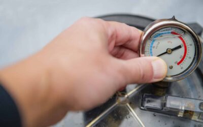 A Homeowner Checks A Water Pressure Gauge After Experiencing Low Water Pressure In House Appliances.