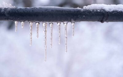 A Frozen Pipe During A Snowy Day, Dripping With Icicles.